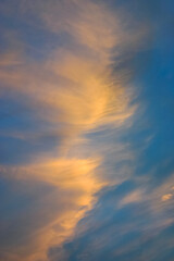 Obraz premium Wispy pink and orange clouds captured by the warm sunset