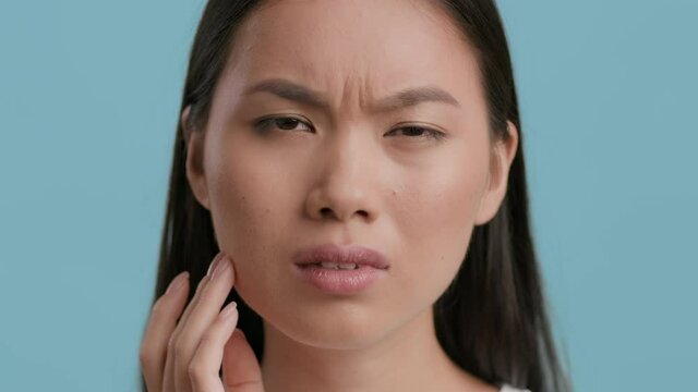 Unhappy Chinese Woman Suffering From Toothache Posing Over Blue Background