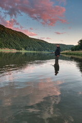 Fisherman angling on the river. Beautiful view over the river Dniester and riverbank