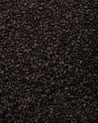 Black sesame seeds in a white plate isolated on a white background. High quality photo