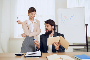 man and woman sitting at the desk discussion emotions communication