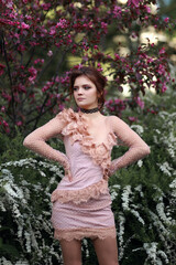 Beautiful girl in short pink dress on flower background