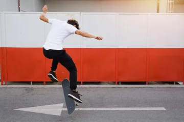 Fotobehang Skateboard skateboarder does tricks outdoors  © cherryandbees