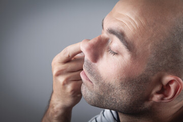 Fototapeta premium Young man with finger in his nose.