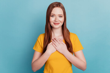 Portrait of lovely pretty lady good mood hands chest on blue background