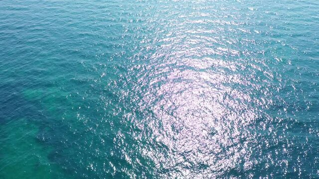 Top View Slow motion looping c ripples and wave, Refraction of sunlight top view texture sea side, Foaming and Splashing in the Ocean, Sunny Day, Slow Motion Video. Veiw from drone