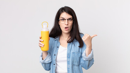 pretty woman looking astonished in disbelief and holding a coffee thermos