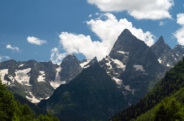 Beautiful mountain landscape with snowy peaks and clouds.