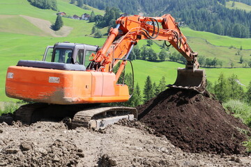 Orange mechanical digger working on a field