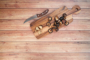 raw champignon mushroom ion a chopping board on table 