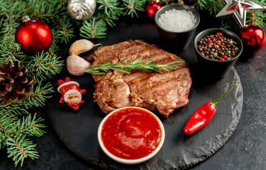 Christmas raw ribeye steak with Christmas tree decorations on stone background