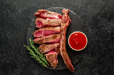 grilled Tomahawk steak with spices on a stone background 