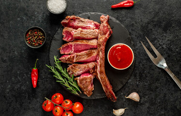 grilled Tomahawk steak with spices on a stone background 