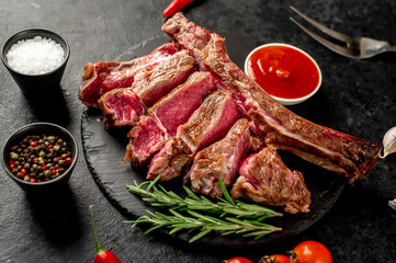 grilled Tomahawk steak with spices on a stone background 