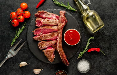 grilled Tomahawk steak with spices on a stone background 