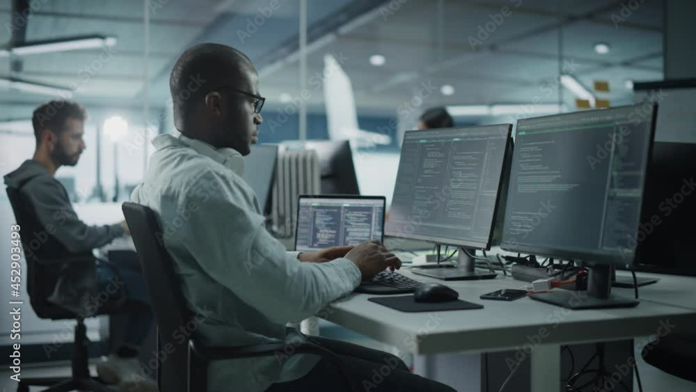 Poster Authentic Office: Motivated Black IT Programmer Working on Desktop Computer. Male Website, Software Engineer Developing App, Program, Video Game. Terminal with Coding Language. Tracking Side Medium