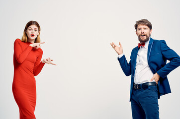 a man in a suit next to a woman in a red dress emotions hand gestures isolated background