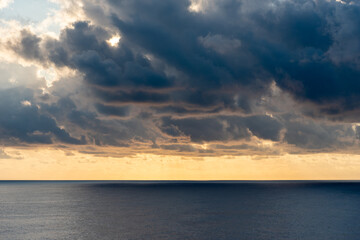 Sunset cloudy sky over the calm ocean.