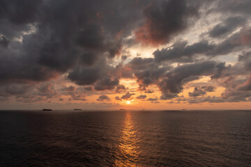Mystical and inspirational beautiful sunset cloudy sky, over the calm ocean.