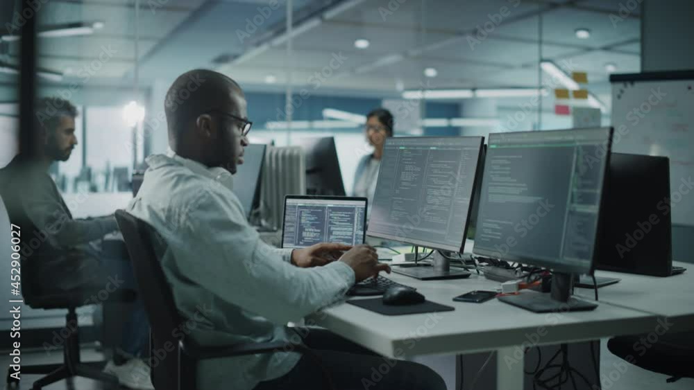 Poster Multi-Ethnic Office: Black IT Programmer Working on Desktop Computer. Male Specialist DoingWebsite, Software Engineer Developing App, Program, Video Game. Terminal with Coding Language. Static Shot