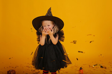 beautiful happy little blonde girl in a black dress black hat red tights with black stripes tinsel...