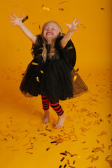 beautiful happy little blonde girl in a black dress black hat red tights with black stripes tinsel...