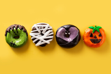 Assortment of Halloween donuts on yellow background