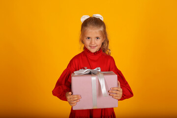 beautiful happy blonde girl in a red dress with a gift box in her hands holiday birthday