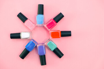Fototapeta premium multicolored nail polishes on a pink background.