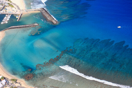 Cristalline blue lagoon waters of West Reunion island and white sand beach