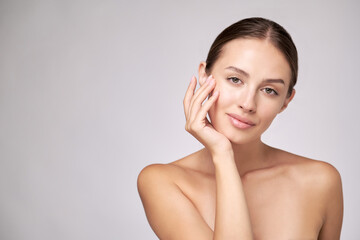 Obraz premium Beautiful Young Woman with Clean Fresh Skin standing over light grey background