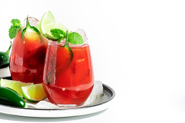 Spicy cocktail with vodka, tomato juice, jalapeno pepper, ice, lime and salt, white background, hard light, negative space