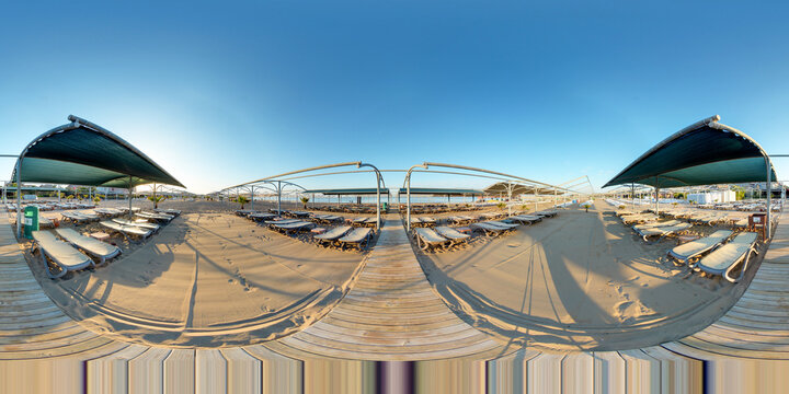360 degree panorama of hotel and beach club beach at sunrise.