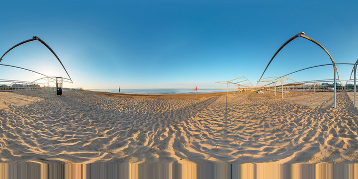 360 degree panorama of hotel and beach club beach at sunrise.
