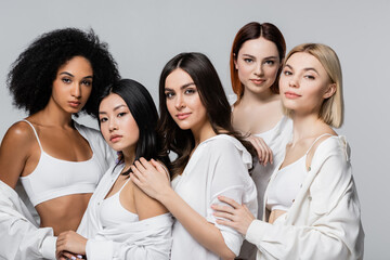 asian and african american models in white shirts posing with young women isolated on grey