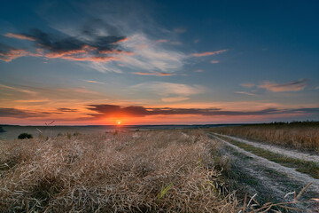sunset over the field and road in Central russia
