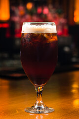 Ice cold glass of dark beer with foam. Stout beer freshly poured