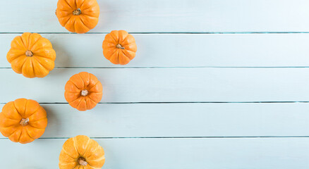 Top view of orange pumpkin on pastel wooden background with copy space for text. Halloween, autumn...