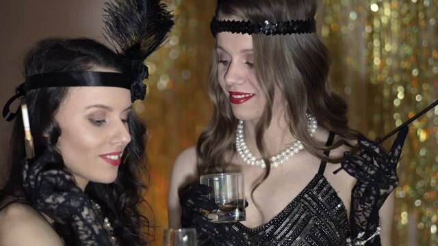 People dressed in style of Roaring twenties having fun on Gatsby party. Vintage, retro party, fashion, girls friends concept