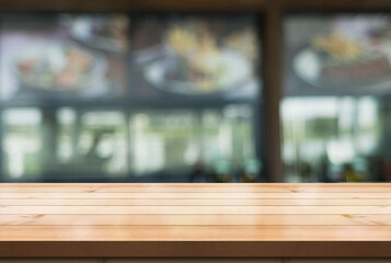 Empty wooden table top with lights bokeh on blur restaurant background.