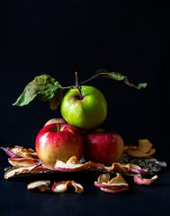 A mountain of apples on birch bark, dry fruits all on a dark background 