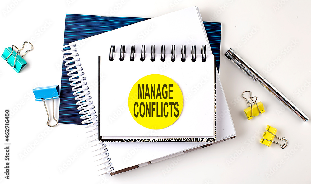 Poster sticker with manage conflicts text on the notebooks on the white background