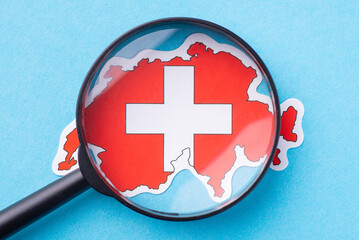 Magnifying glass on map of Switzerland. Concept of closer look the European country, study its...