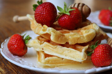 Belgian waffles with fresh berries strawberry , honey and cappuccino coffee for breakfast