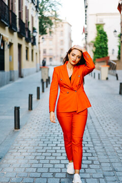 Redhead Woman In Orange Suit In City Street