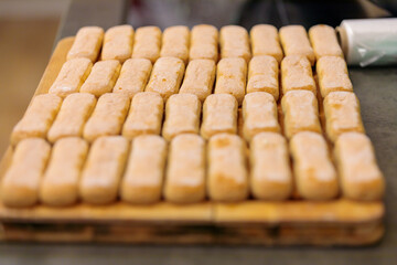 Biscuit biscuits for making tiramisu. Savoyards are laid out on a cutting board. Close-up.