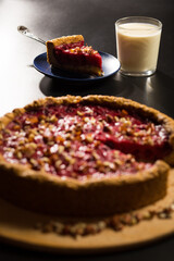 Fresh fruit pie. Piece of cake with milk on black.