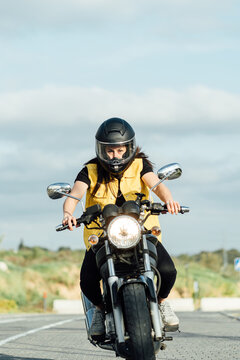 Woman riding motorcycle along road