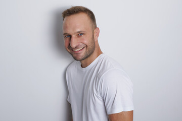 Obraz premium Man smiling in a white background with white t-shirt