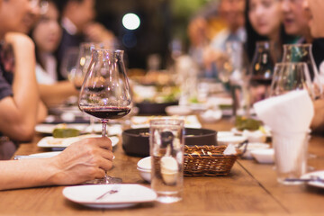 Selected focus group of friends dining at restaurant drinking red wine. indoor